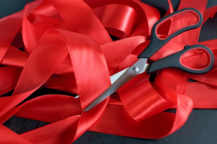 Spool of red tape with scissors.